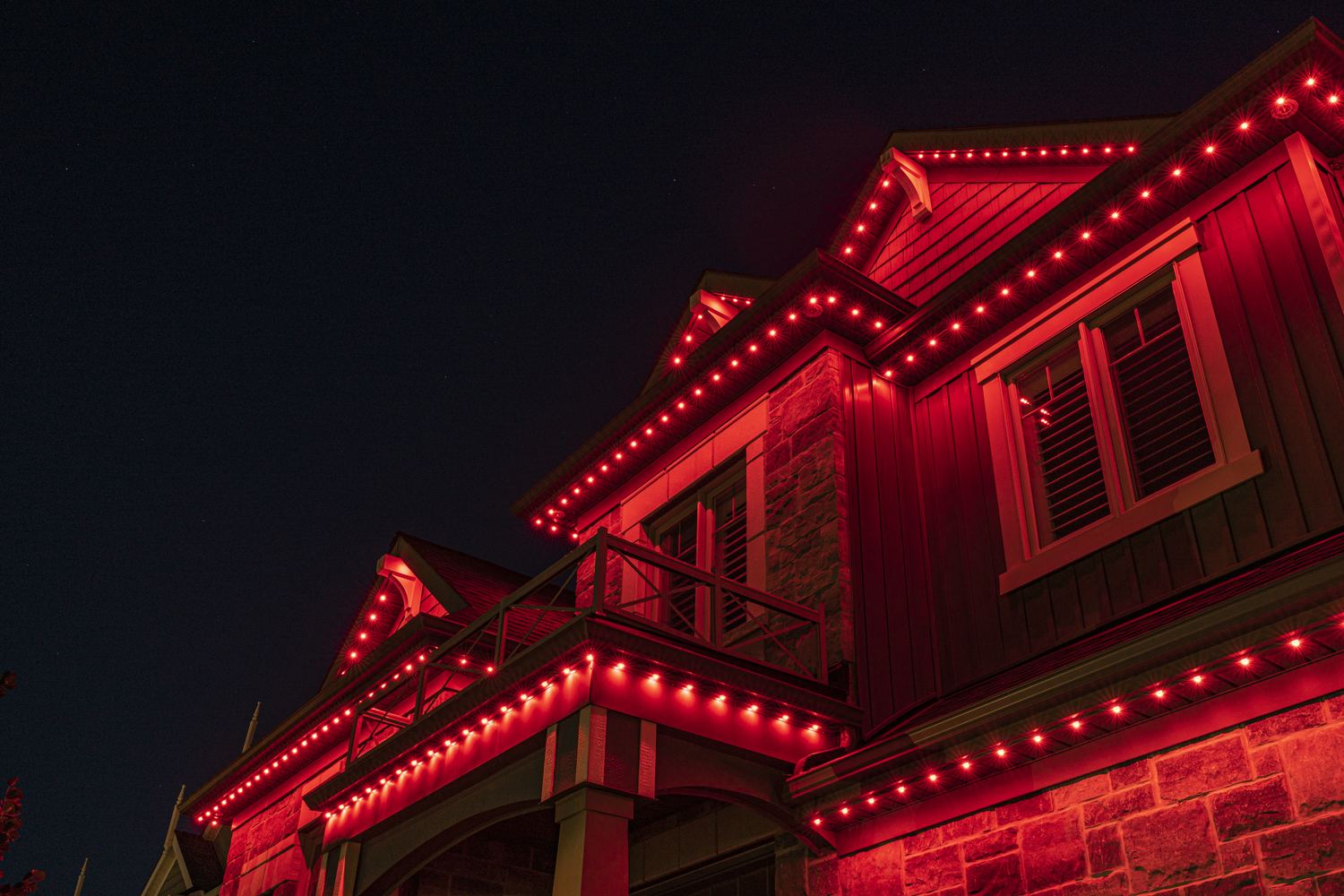 A home lit entirely in classic solid red permanent LED lighting for Christmas